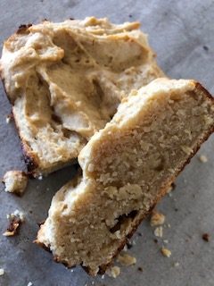 A sliced loaf of lemon bread on a rustic cutting board